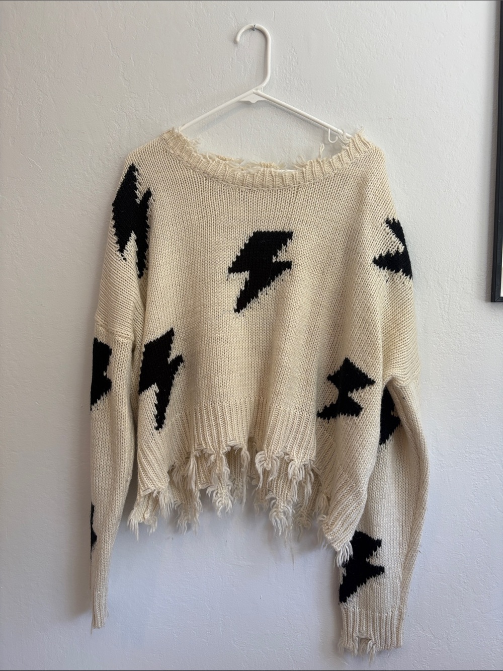 Cream Off-the-Shoulder Sweater with Black Lightning Motifs